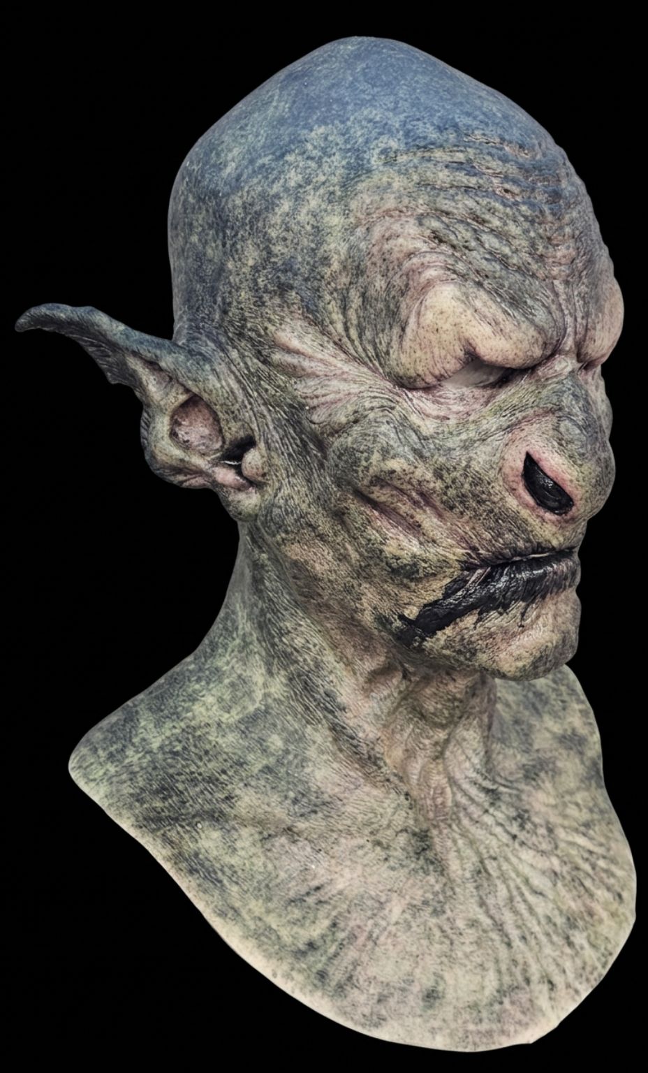 Mr E Masks Orc realistic silicone mask in green mottled colourway, side profile view showing detailed wrinkled texture and pointed ear
