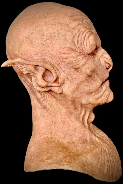 Close-up of a detailed alien head sculpture on a black background