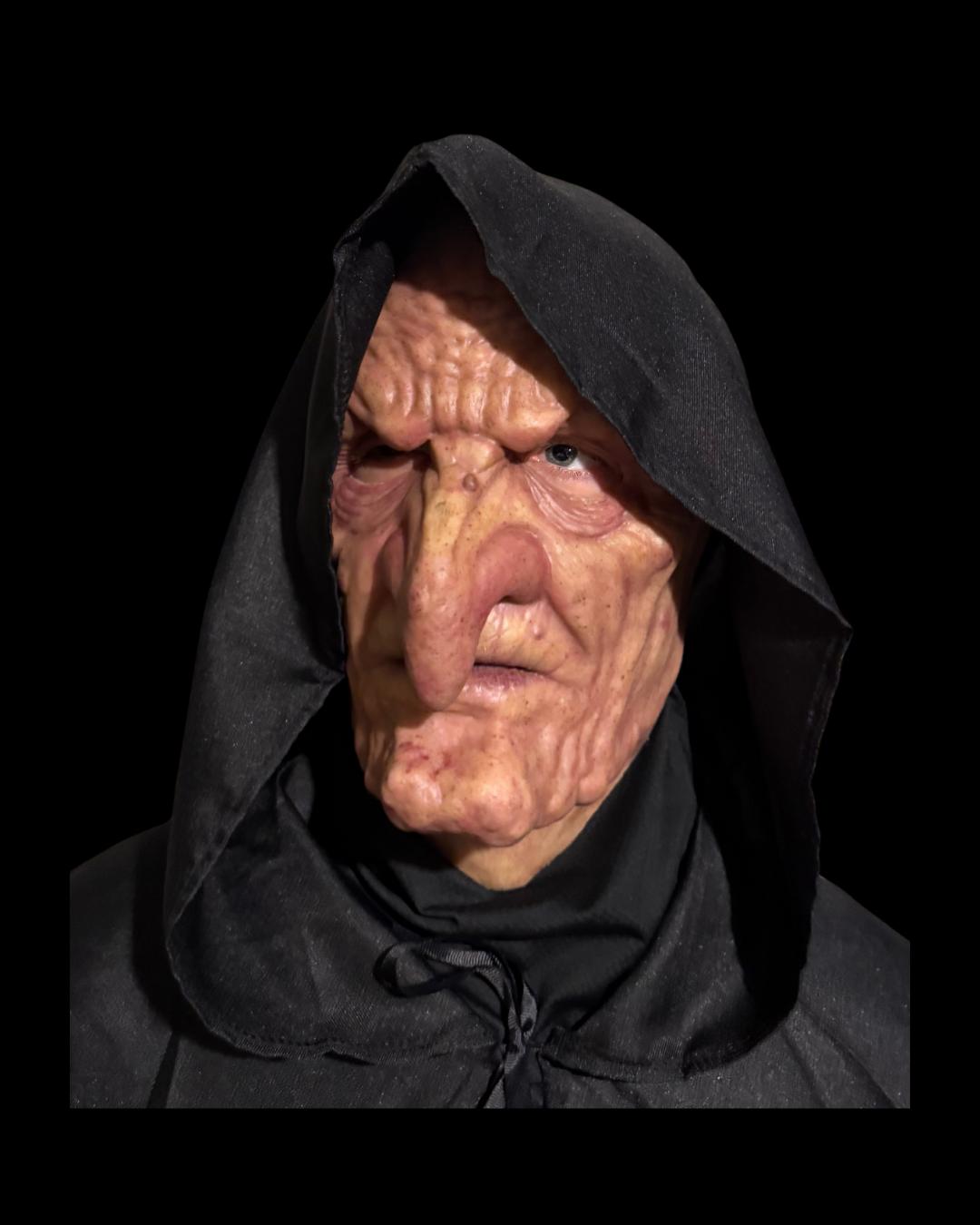 Old Hag silicone witch mask in a black hood, front view