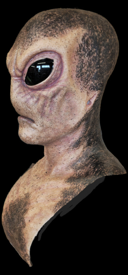 Close-up of an alien head prop with a dark background