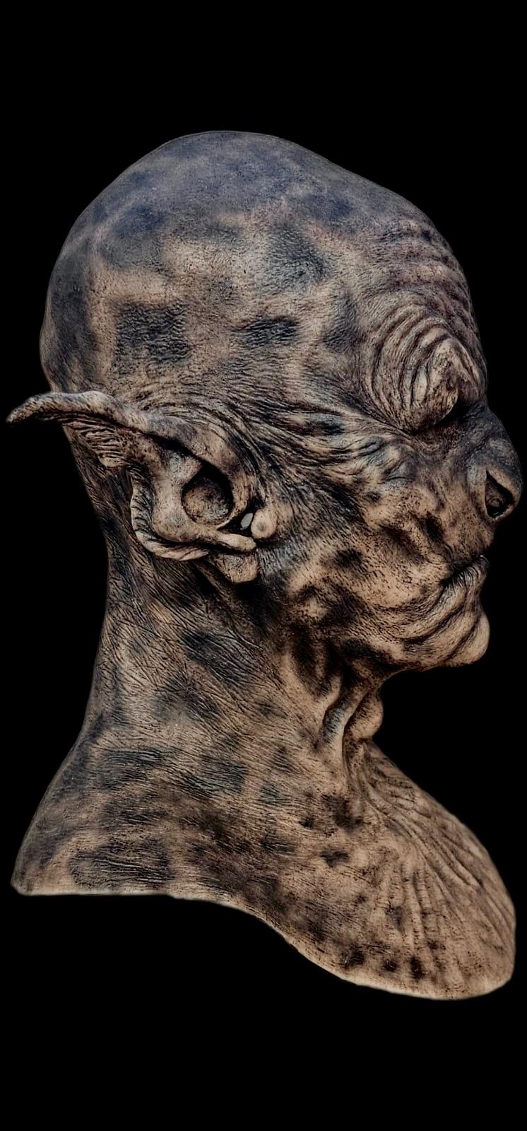 Detailed sculpture of a creature's head on a black background