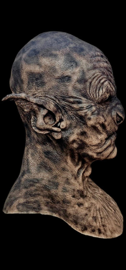 Detailed sculpture of a creature's head on a black background