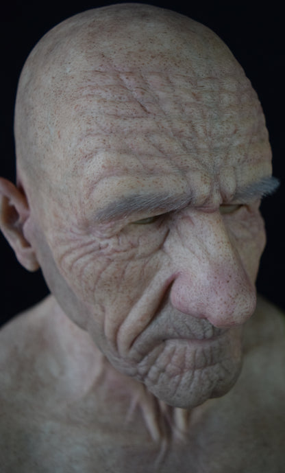 A close-up of a silicone mask with hand-punched eyebrows to enhance a costume's realistic appearance